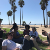 A group of students beside some palm trees